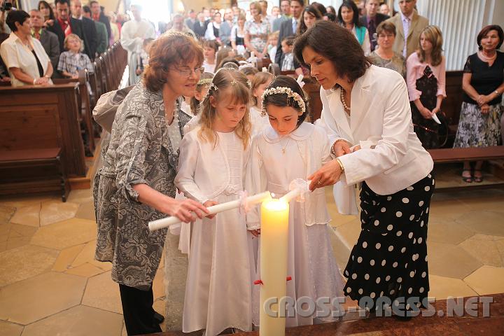 2009.05.21_10.03.30.jpg - Die Klassenlehrerinnen Leichtfried und Gruber helfen beim Anzünden der Erstkommunionskerzen an der Osterkerze.